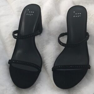 Black block-heeled sandals with two straps and embellished with rhinestones.